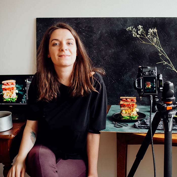 Portrait Charlie Cocotte dans son studio, devant une mise en scène de photographie culinaire